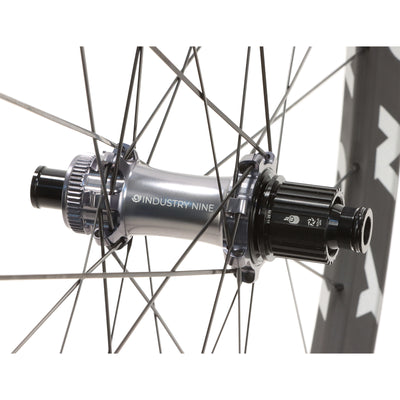 Bicycle hub with 'Industry Nine' branding on Reynolds carbon XC bicycle wheels and a white background