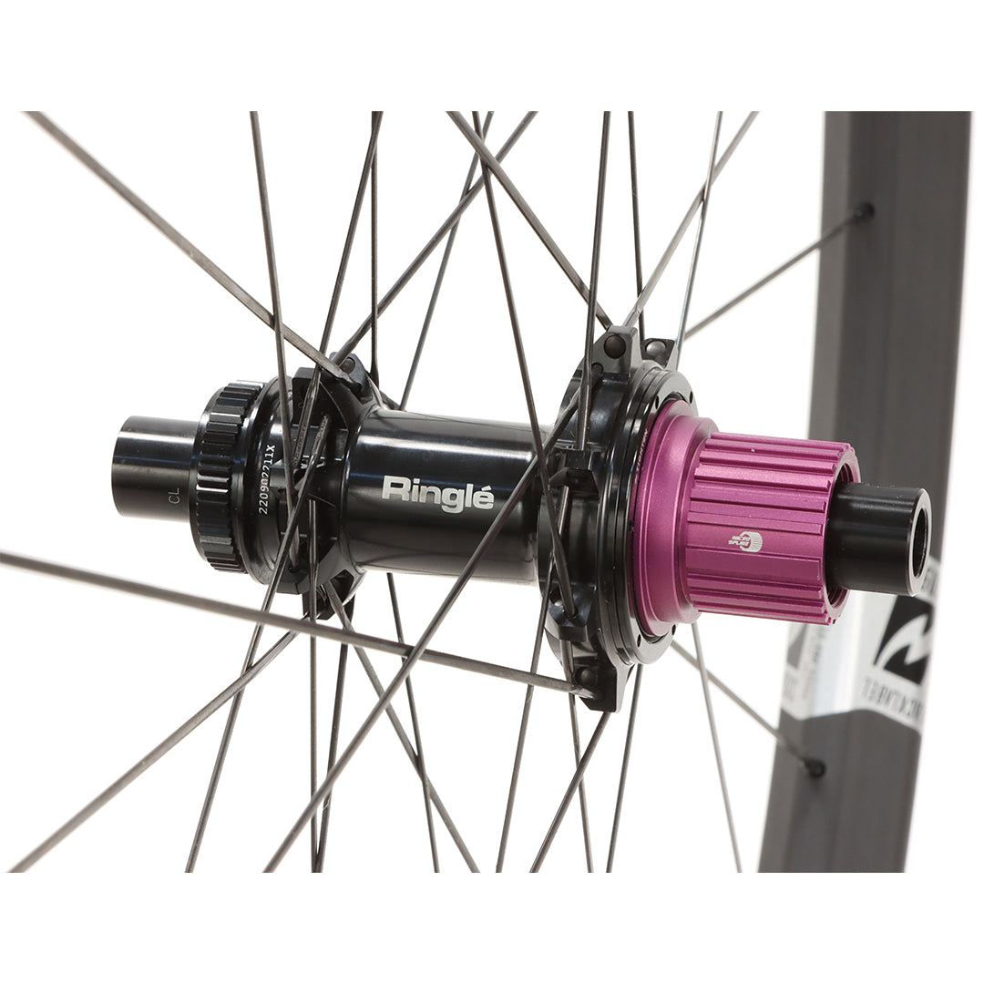 Close-up of a bicycle hub Ringle branding on a Reynolds 309 Expert XC carbon wheel on white background