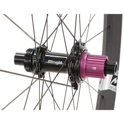 Close-up of a bicycle hub Ringle branding on a Reynolds 309 Expert XC carbon wheel on white background