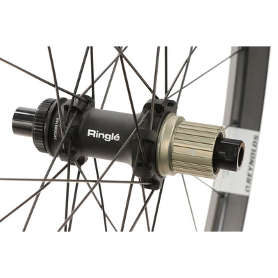 Close-up of a bicycle hub with 'Ringle' branding on Reynolds Trail 309 XC carbon wheel and a white background